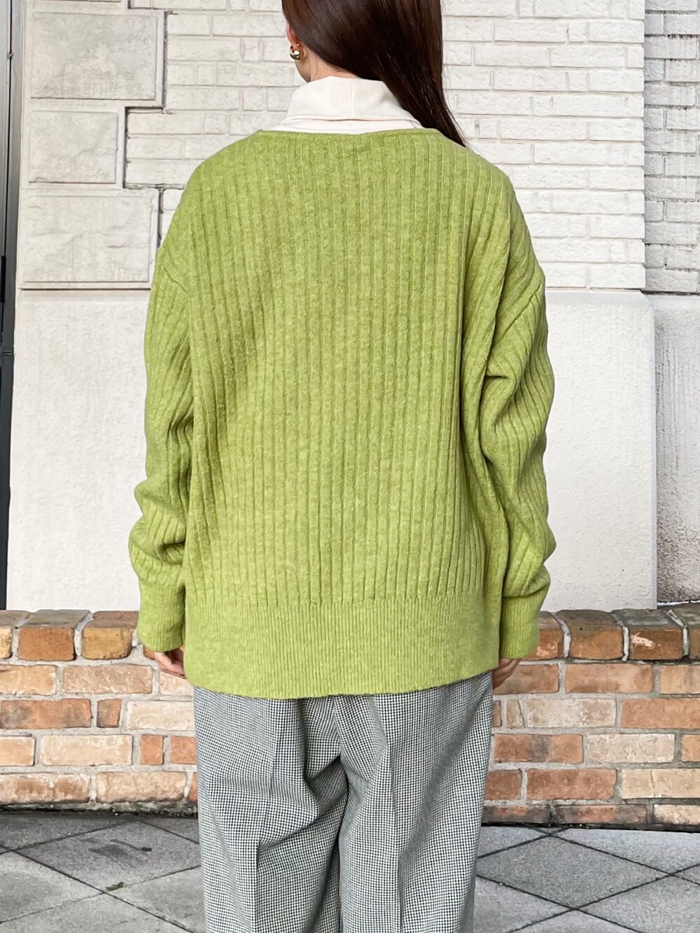 ブラック系のその他アウター、グリーン系のニット/セーター、ホワイト系のTシャツ/カットソーを着用したレディースの冬コーディネートの7枚目の写真