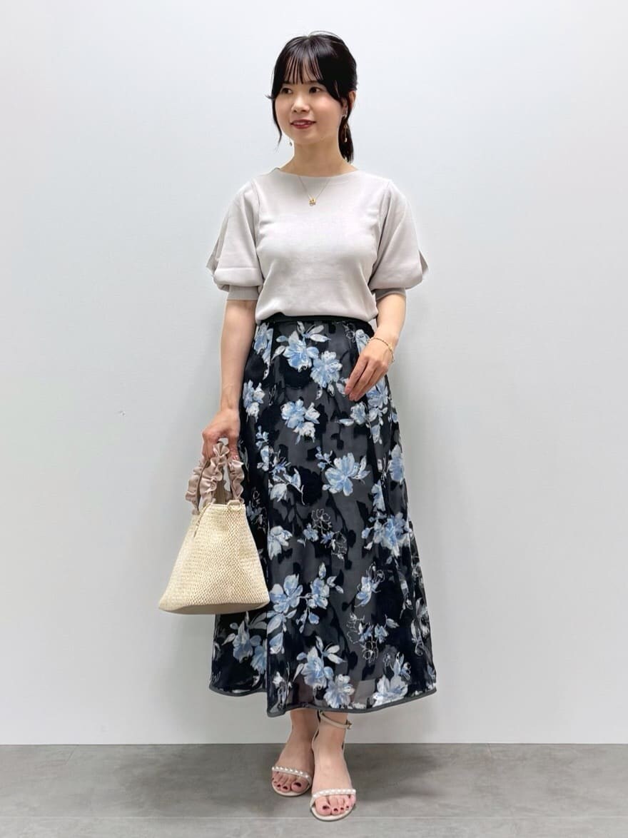 ベージュ系のニット/セーター、グレー系のスカート、ベージュ系のトートバッグを着用したレディースの春コーディネートの9枚目の写真