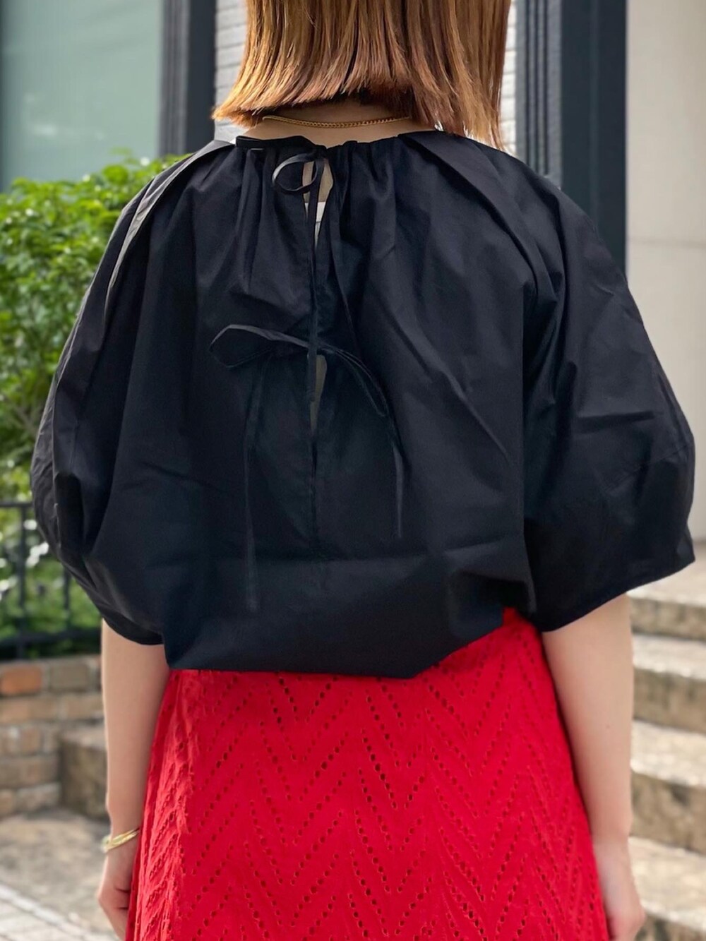 レッド系のスカート、ブラック系のシャツ/ブラウス、ブラック系のショルダーバッグを着用したレディースの夏コーディネートの4枚目の写真