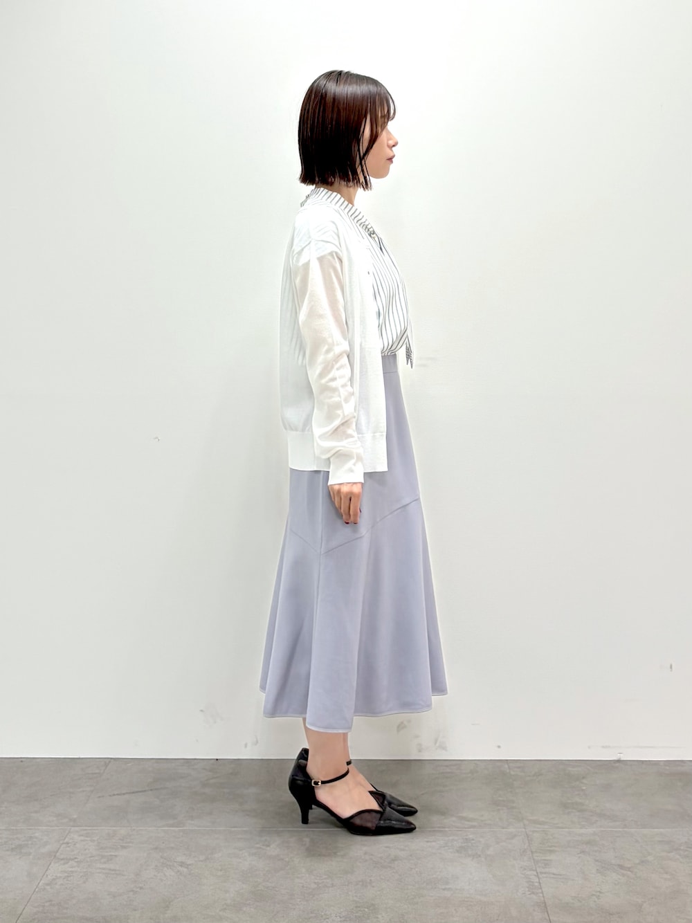 ホワイト系のカーディガン/ボレロ、ベージュ系のシャツ/ブラウス、グレー系のスカートを着用したレディースの夏コーディネートの2枚目の写真