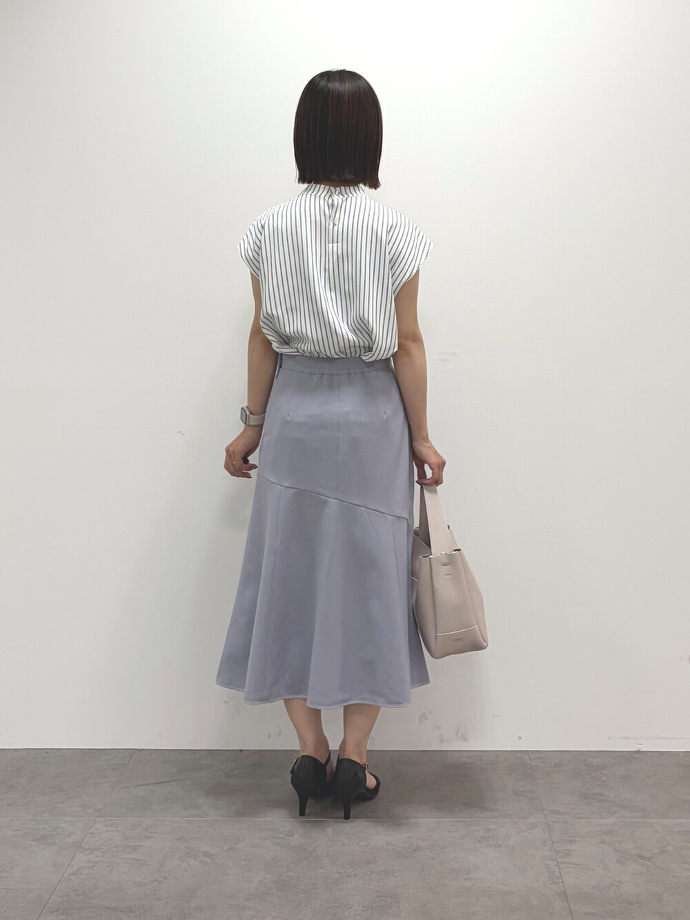 ホワイト系のカーディガン/ボレロ、ベージュ系のシャツ/ブラウス、グレー系のスカートを着用したレディースの夏コーディネートの9枚目の写真