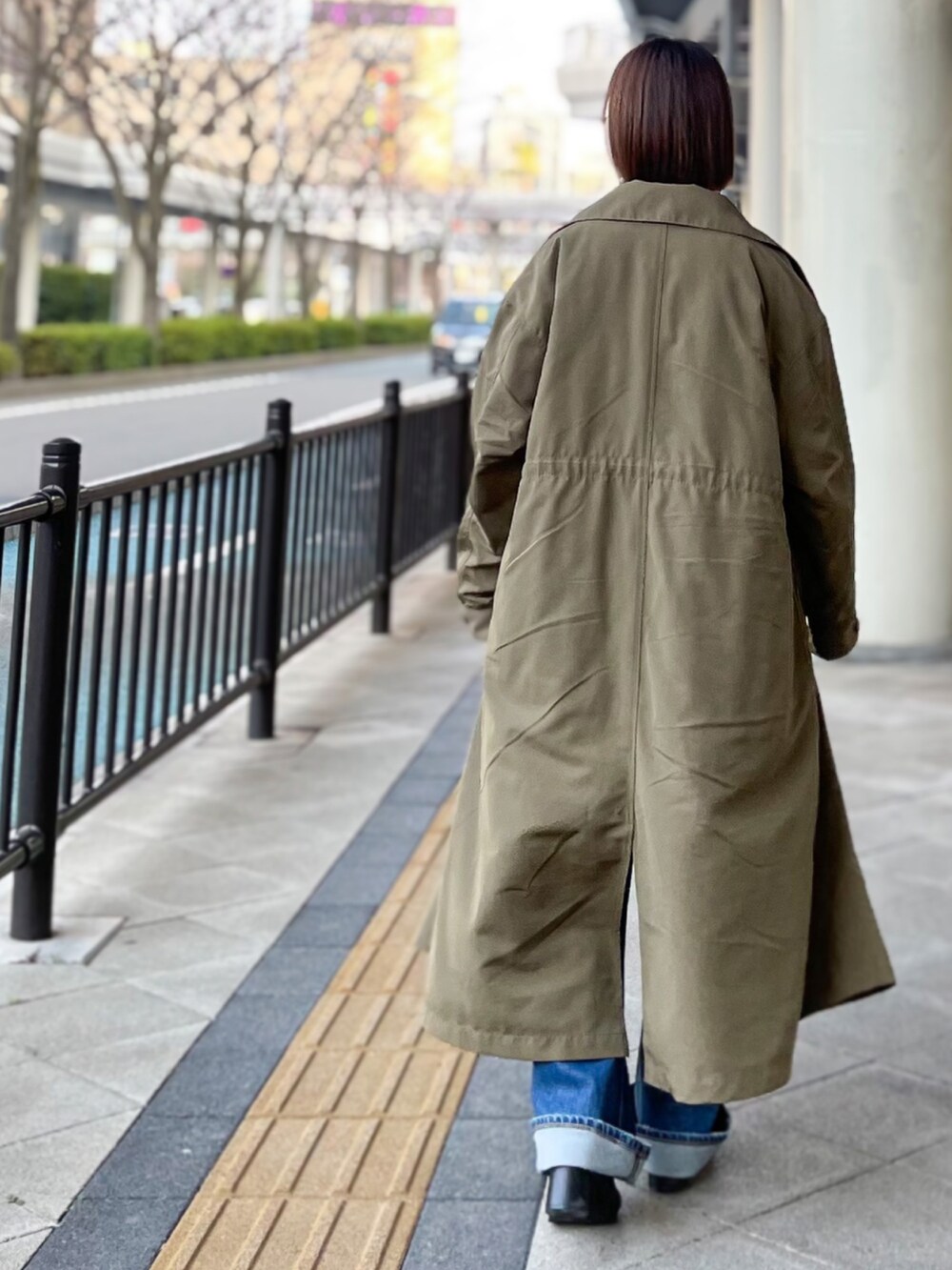 ブラック系のブーツ、グリーン系のその他アウター、ブルー系のデニムパンツを着用したレディースの冬コーディネートの2枚目の写真