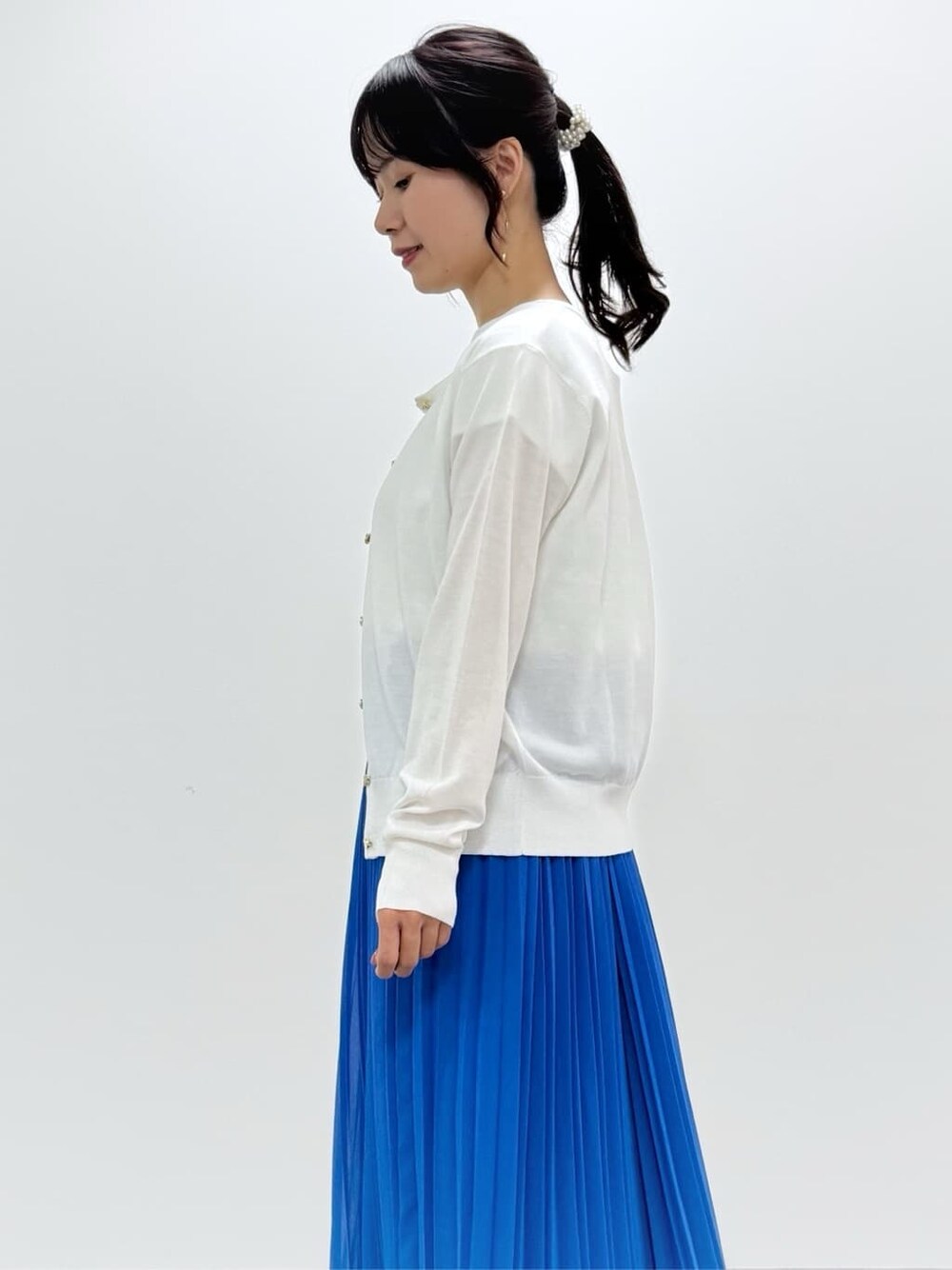 ホワイト系のTシャツ/カットソー、ブルー系のスカート、ベージュ系のトートバッグを着用したレディースの春コーディネートの9枚目の写真