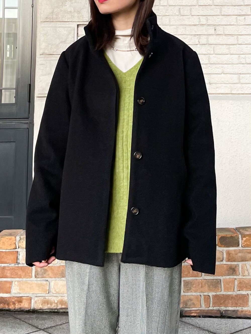 ブラック系のその他アウター、グリーン系のニット/セーター、ホワイト系のTシャツ/カットソーを着用したレディースの冬コーディネートの2枚目の写真