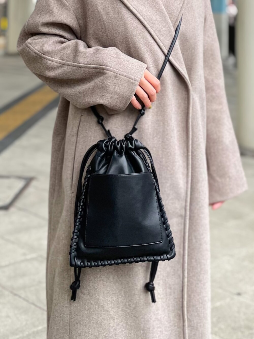 ブラック系のニット/セーター、ベージュ系のその他パンツ、ブラウン系のチェスターコートを着用したレディースの冬コーディネートの5枚目の写真