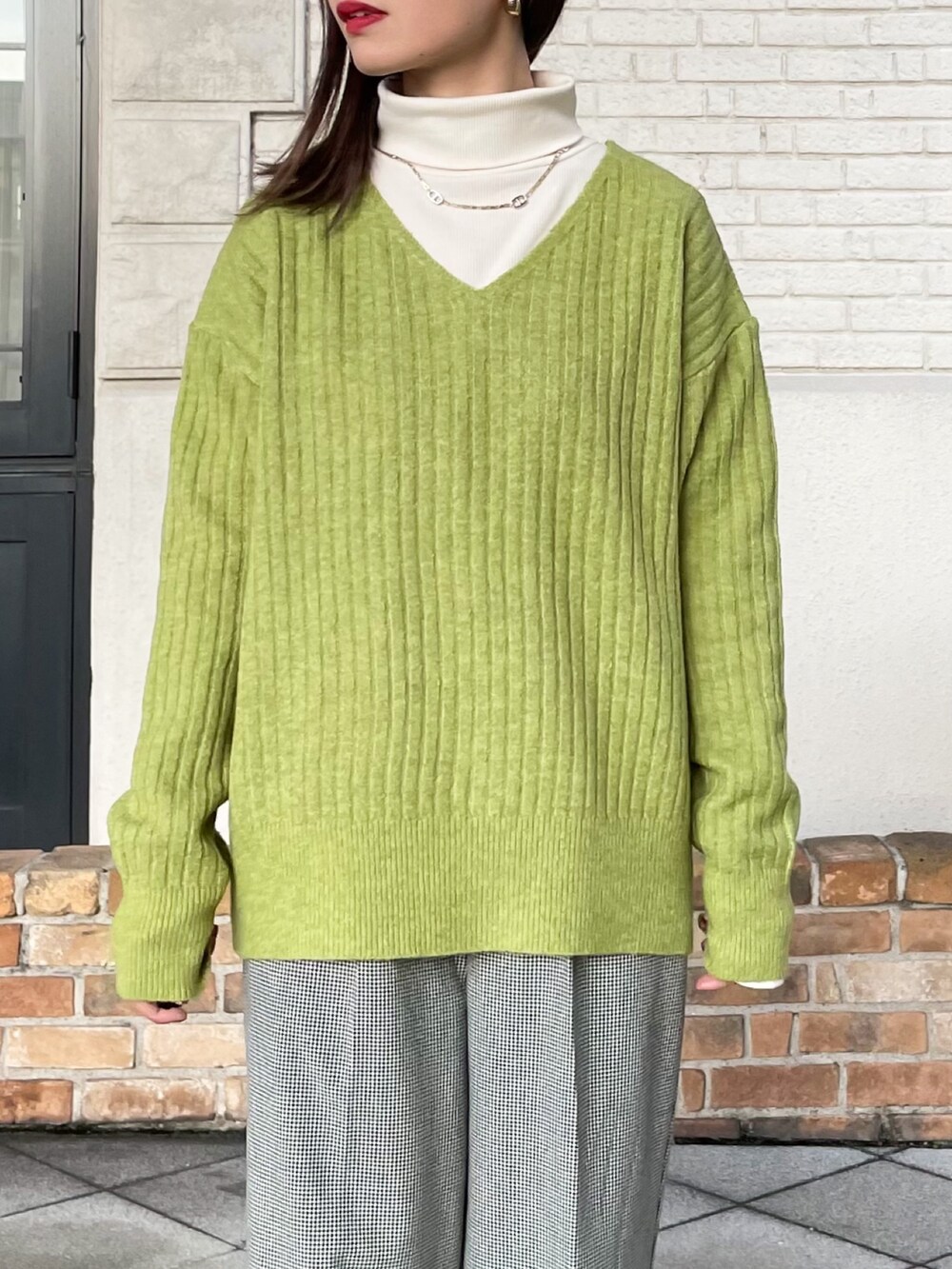 ブラック系のその他アウター、グリーン系のニット/セーター、ホワイト系のTシャツ/カットソーを着用したレディースの冬コーディネートの6枚目の写真
