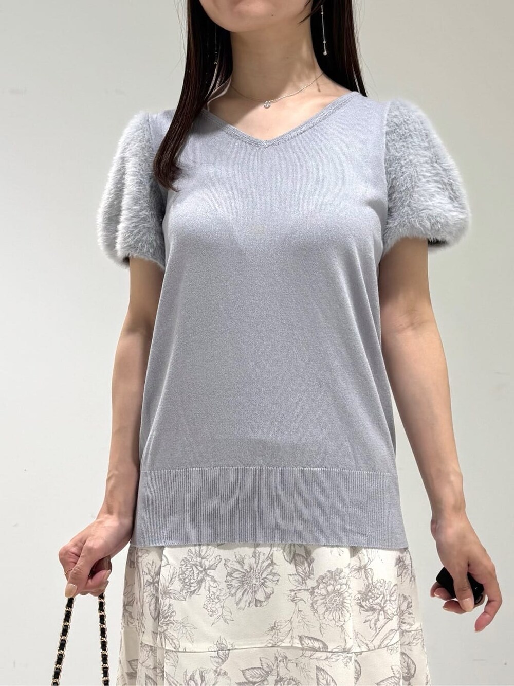 ブルー系のニット/セーター、グレー系のスカート、ブラック系のショルダーバッグを着用したレディースの秋コーディネートの3枚目の写真