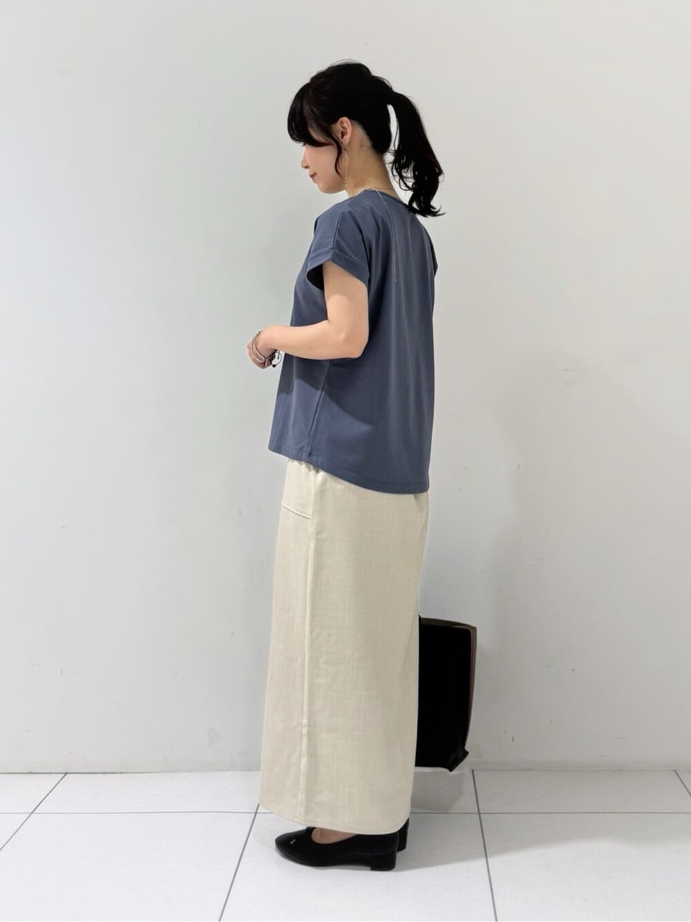 ブラック系のカーディガン/ボレロ、グレー系のTシャツ/カットソー、ベージュ系のスカートを着用したレディースの夏コーディネートの7枚目の写真