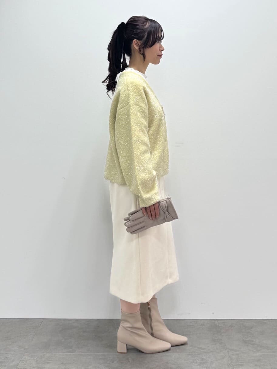イエロー系のカーディガン/ボレロ、ホワイト系のTシャツ/カットソー、ホワイト系のスカートを着用したレディースの秋コーディネートの4枚目の写真