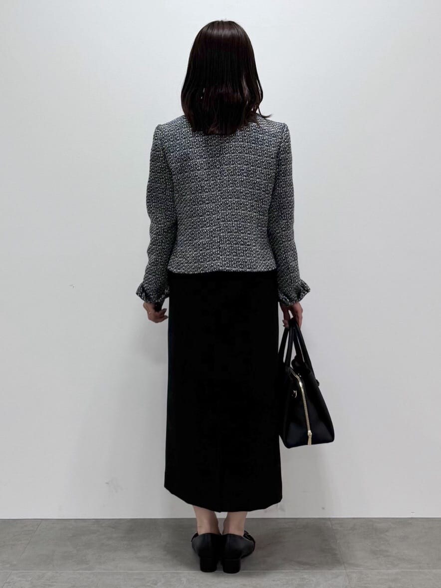 ブラック系のノーカラージャケット、ブラック系のワンピース、ホワイト系のシャツ/ブラウスを着用したレディースの冬コーディネートの4枚目の写真