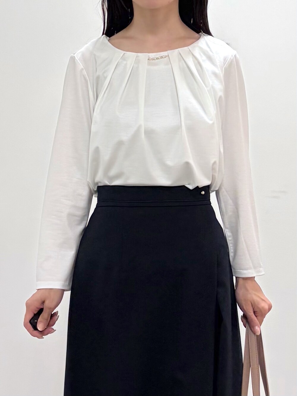 ブラック系のパンプス、ベージュ系のトートバッグ、ブルー系のスカートを着用したレディースの春コーディネートの7枚目の写真