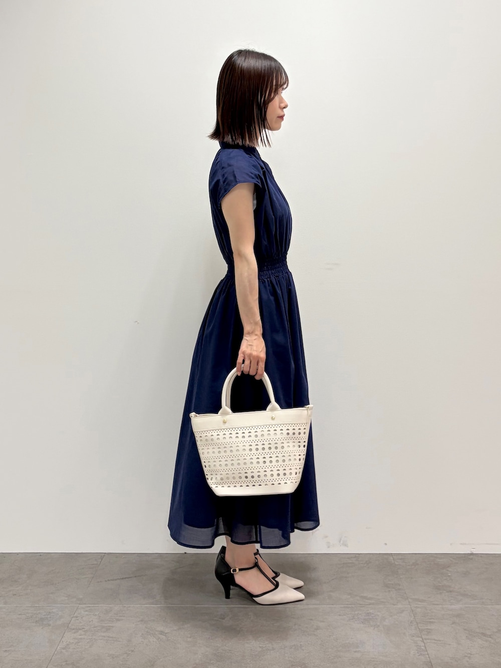 ブルー系のワンピース、ホワイト系のトートバッグ、ベージュ系のパンプスを着用したレディースの春コーディネートの7枚目の写真