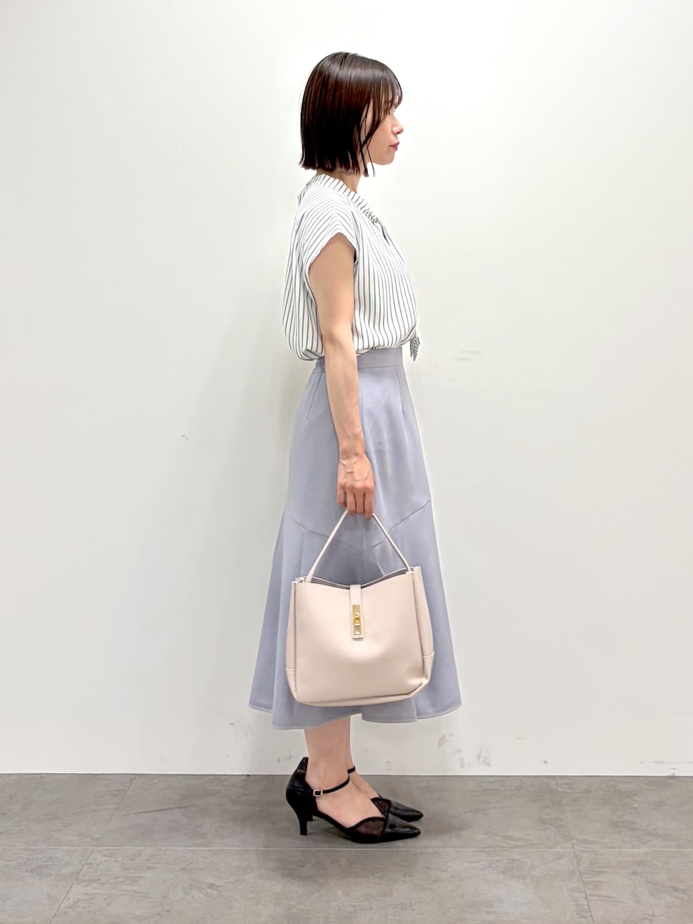 ホワイト系のカーディガン/ボレロ、ベージュ系のシャツ/ブラウス、グレー系のスカートを着用したレディースの夏コーディネートの10枚目の写真