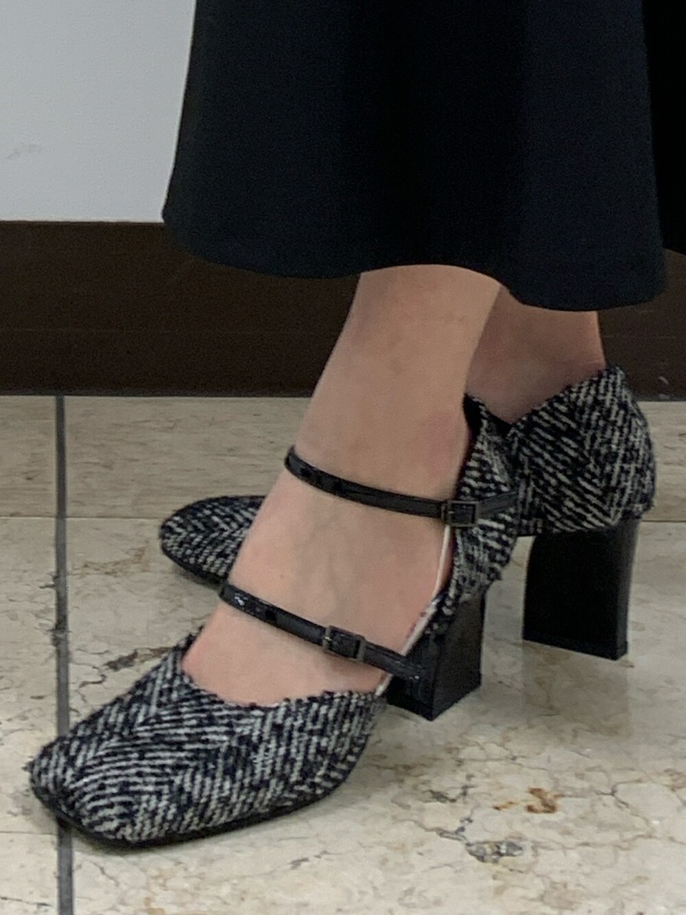 ブラック系のパンプスを着用したレディースの秋コーディネートの2枚目の写真