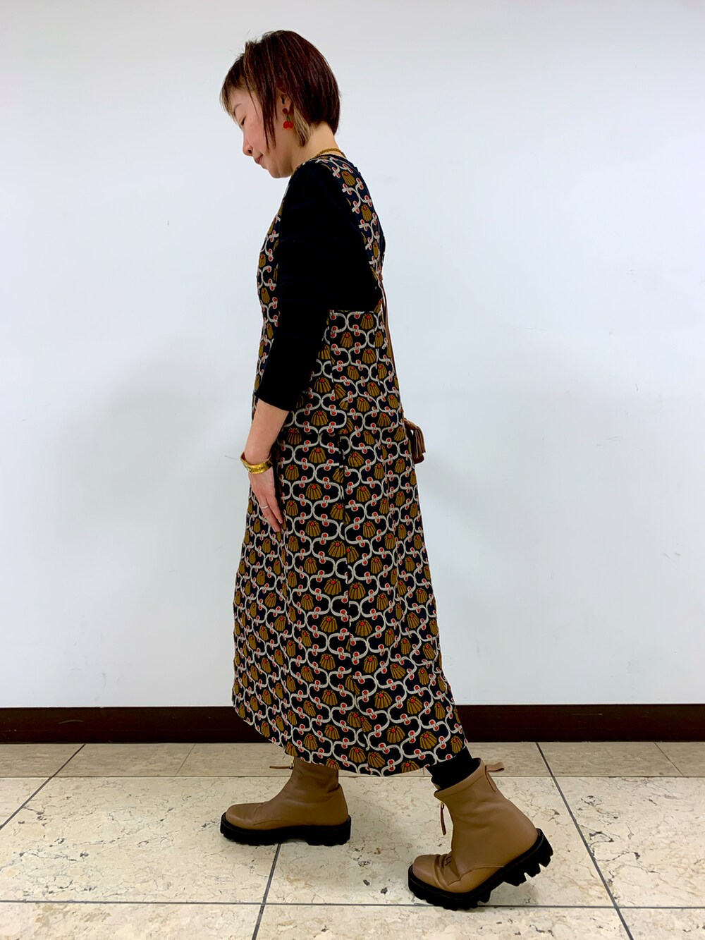 ブラウン系のブーツを着用したレディースの秋コーディネートの2枚目の写真