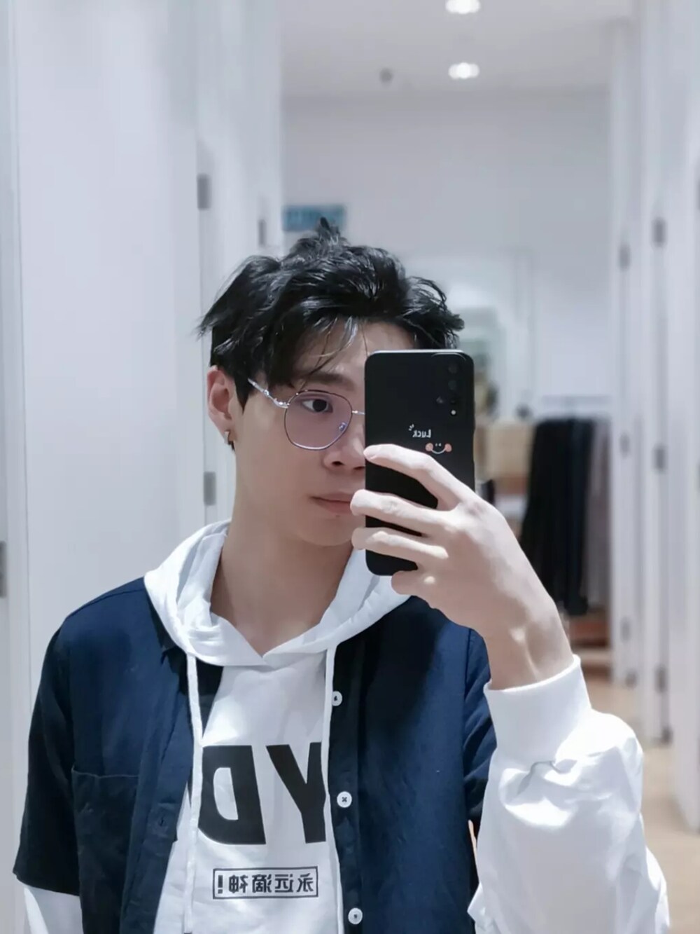 ブルー系のデニムパンツ、ホワイト系のスニーカー、ブルー系のシャツ/ブラウスを着用したメンズの夏コーディネートの3枚目の写真