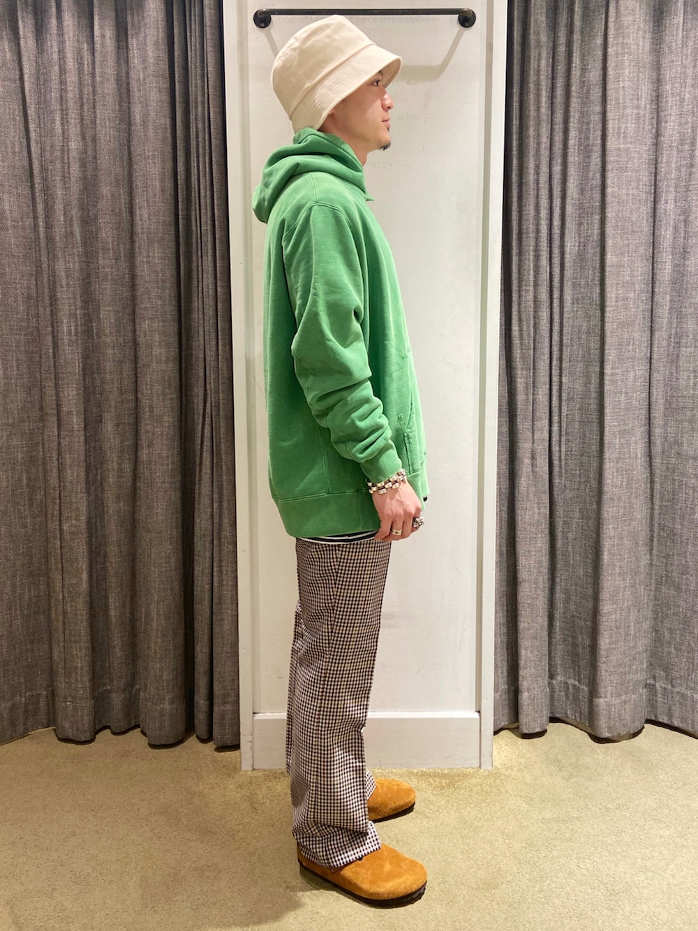 グリーン系のパーカー、ベージュ系のその他パンツ、ブラウン系のサンダルを着用したメンズの秋コーディネートの2枚目の写真