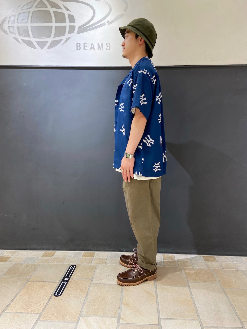 ブルー系のシャツ/ブラウス、ホワイト系のTシャツ/カットソー、ブラウン系のモカシン/デッキシューズを着用したメンズの夏コーディネートの3枚目の写真