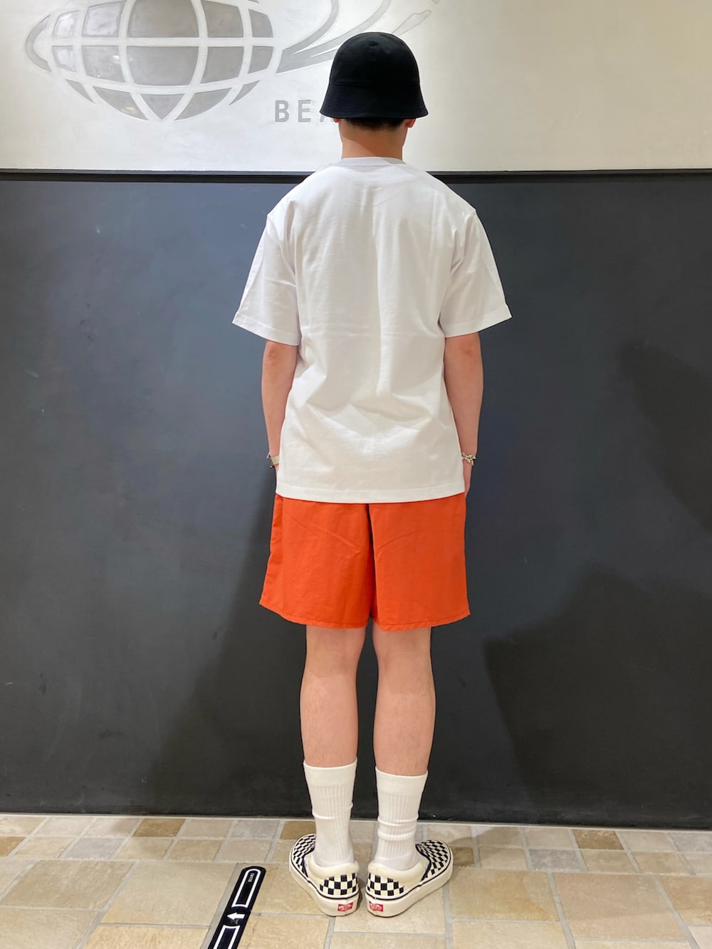 ホワイト系のTシャツ/カットソー、その他のスリッポン、レッド系のパンツを着用したメンズの夏コーディネートの2枚目の写真