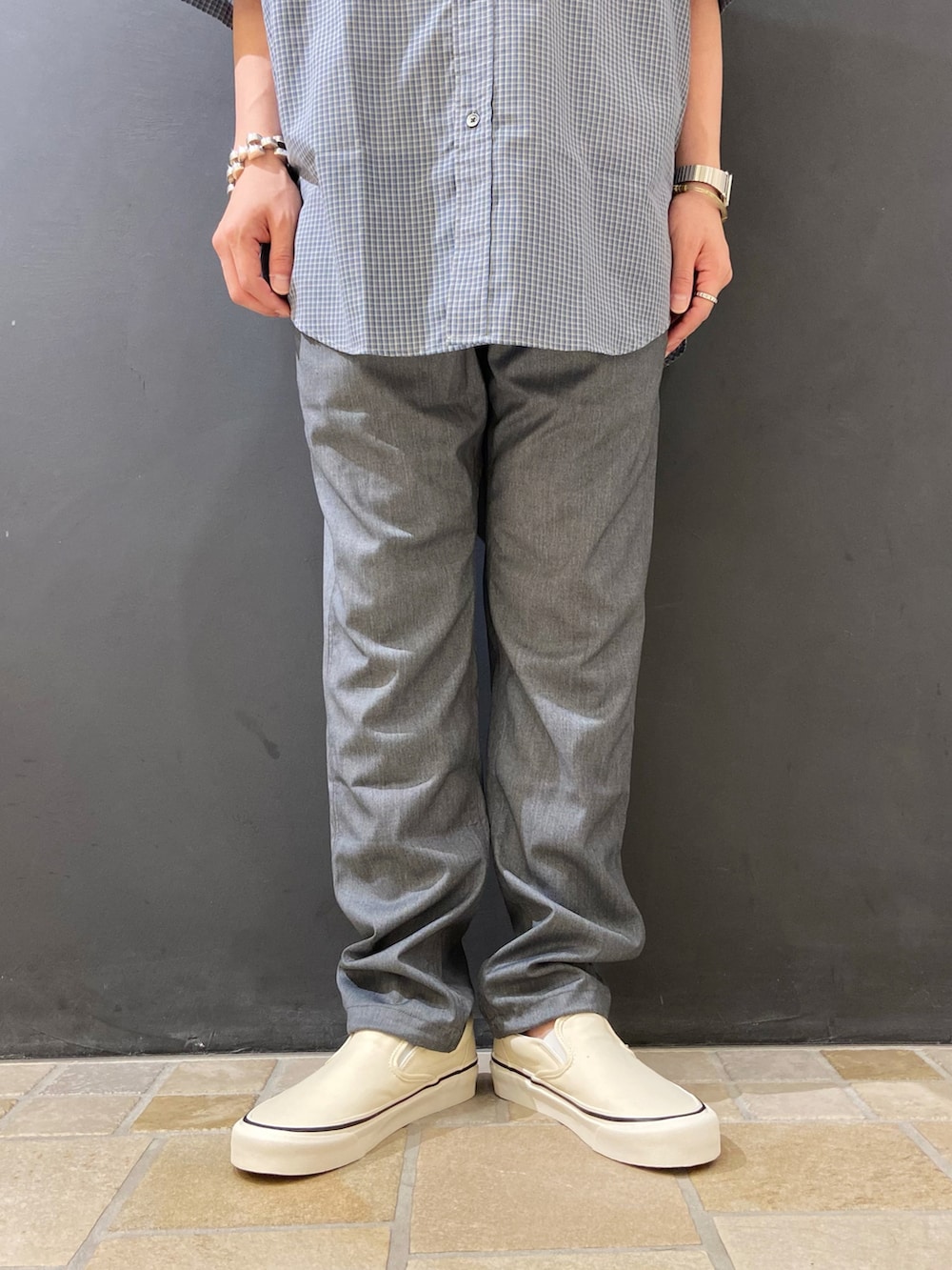 ブルー系のシャツ/ブラウス、グレー系のスラックス、ホワイト系のスリッポンを着用したメンズの夏コーディネートの5枚目の写真