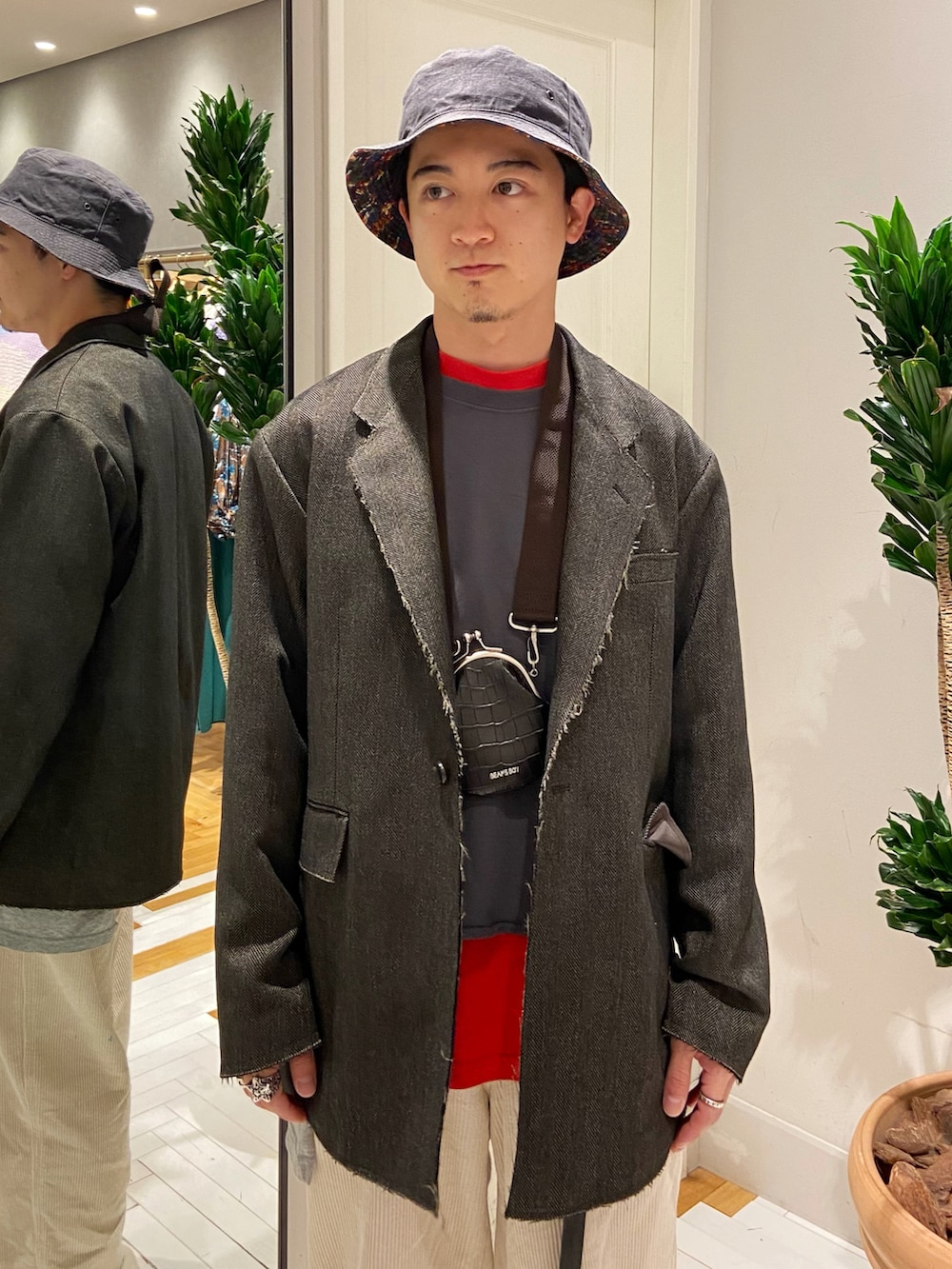 ブラウン系のテーラードジャケット、ホワイト系のパンツ、ブラウン系のスニーカーを着用したメンズの秋コーディネートの3枚目の写真