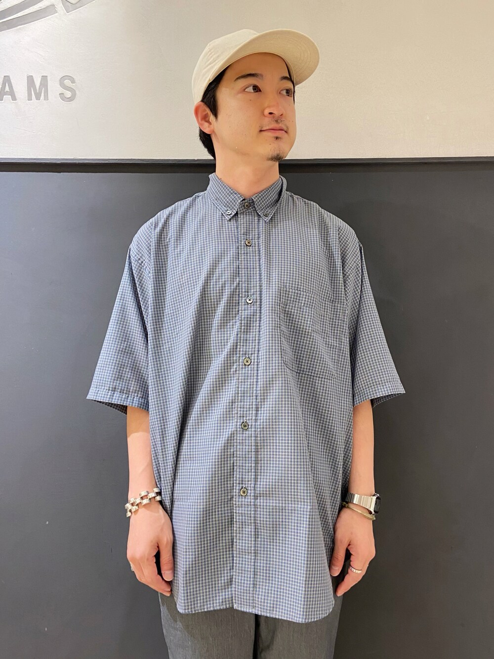 ブルー系のシャツ/ブラウス、グレー系のスラックス、ホワイト系のスリッポンを着用したメンズの夏コーディネートの4枚目の写真