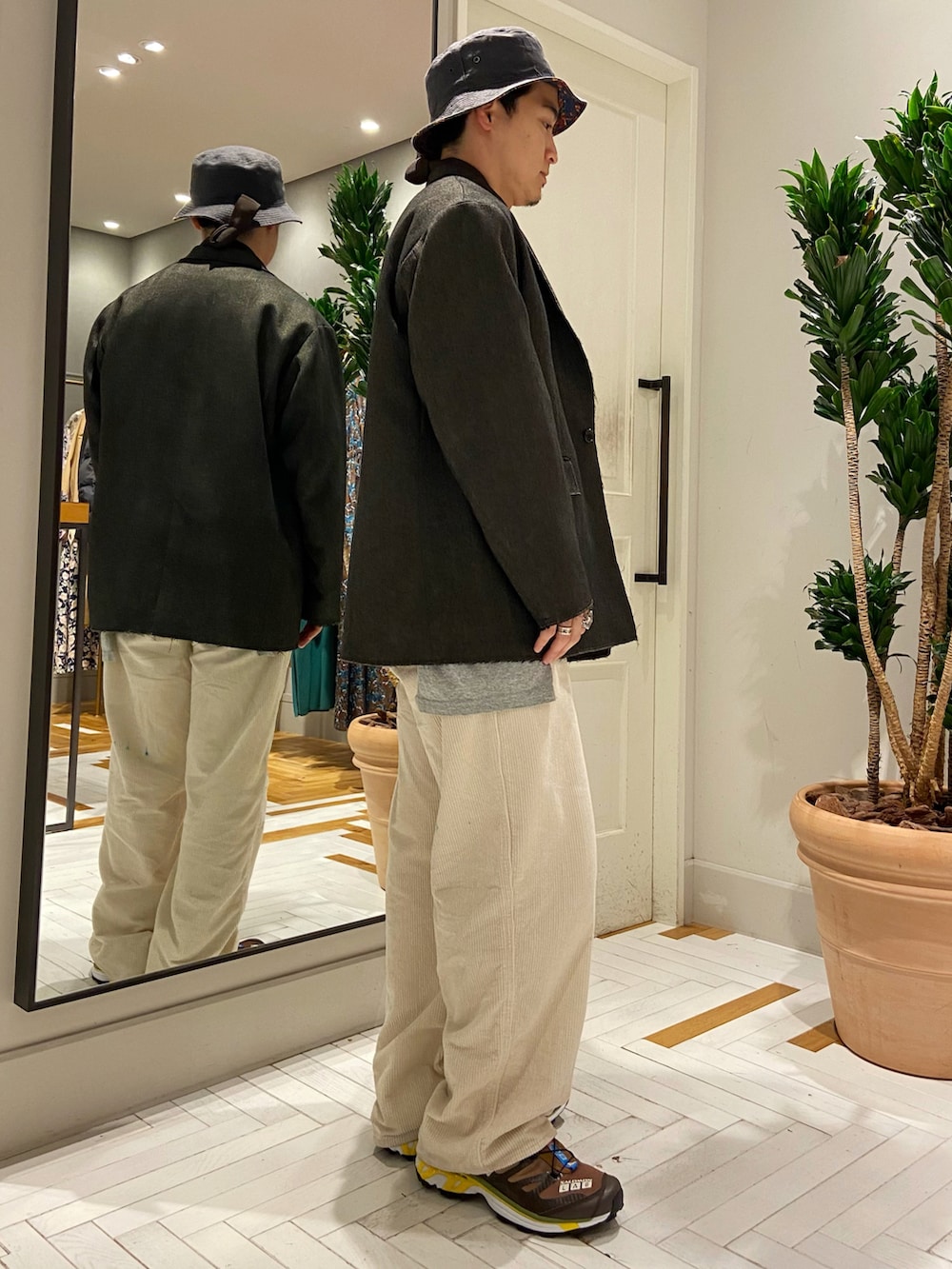 ブラウン系のテーラードジャケット、ホワイト系のパンツ、ブラウン系のスニーカーを着用したメンズの秋コーディネートの2枚目の写真