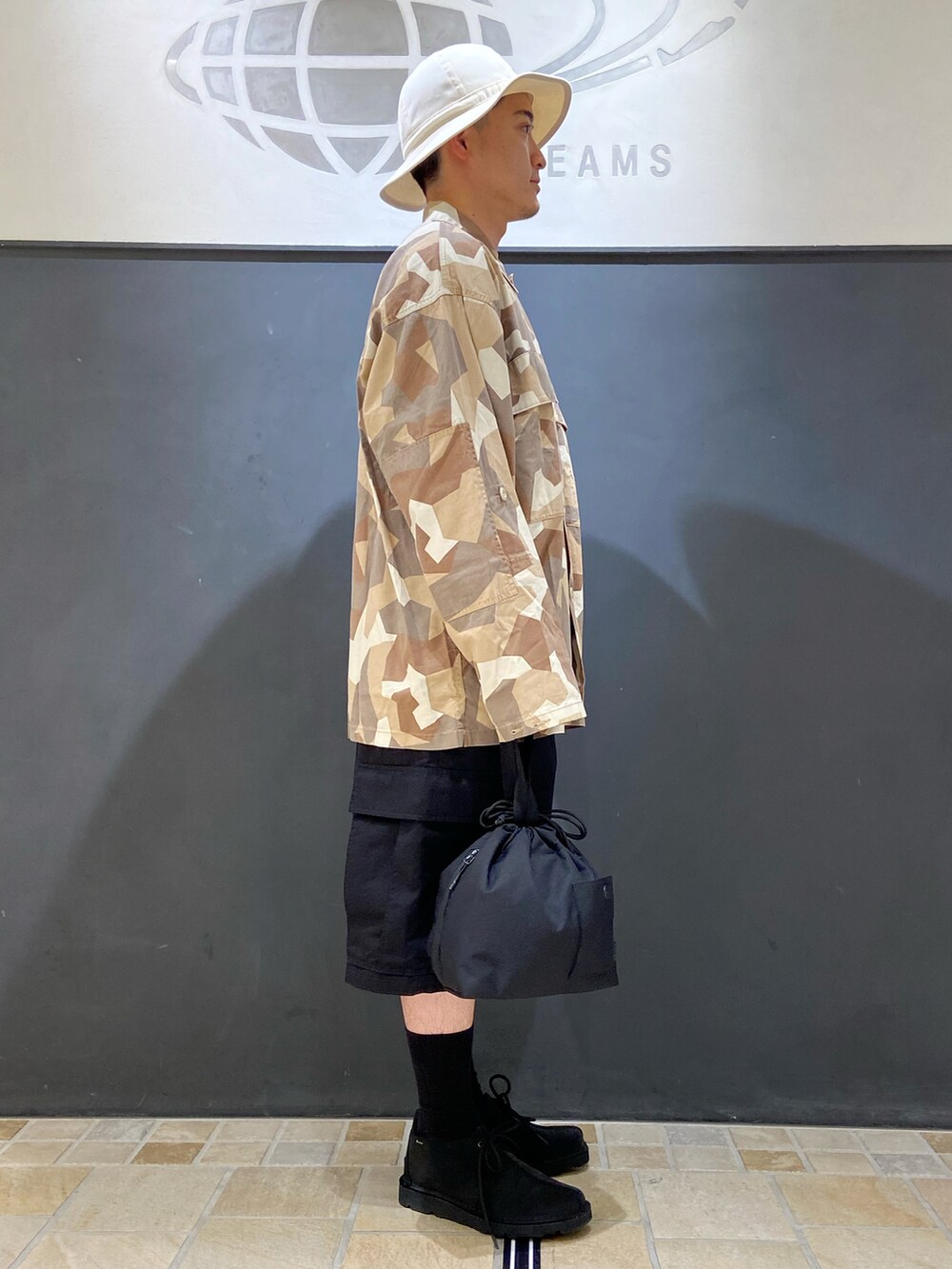 ベージュ系のシャツ/ブラウス、ブラック系のその他パンツ、ブラック系のハンドバッグを着用したメンズの夏コーディネートの2枚目の写真
