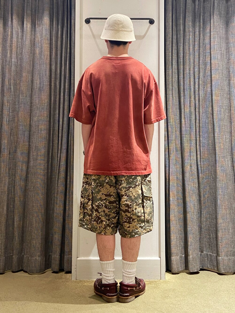 レッド系のTシャツ/カットソー、レッド系のモカシン/デッキシューズ、グリーン系のパンツを着用したメンズの夏コーディネートの3枚目の写真