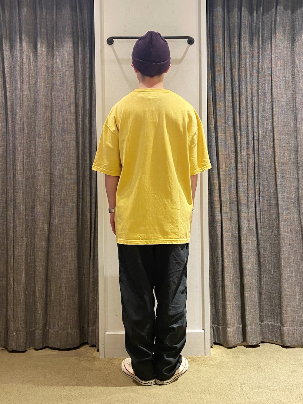 イエロー系のTシャツ/カットソー、ブラック系のカーゴパンツ、ホワイト系のスニーカーを着用したメンズの夏コーディネートの3枚目の写真