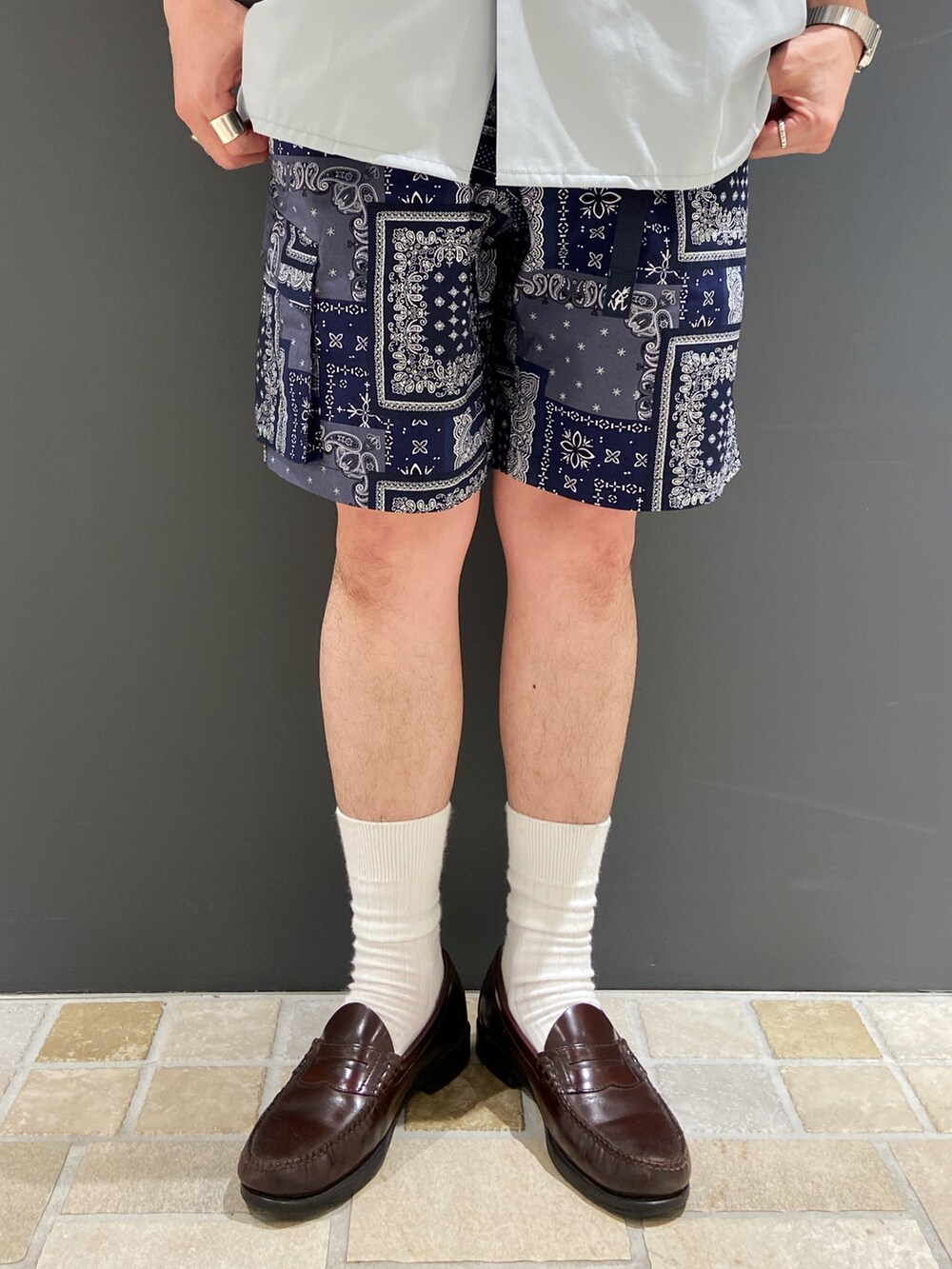 グレー系のシャツ/ブラウス、ブルー系のバッグ、ブラウン系のローファーを着用したメンズの夏コーディネートの4枚目の写真