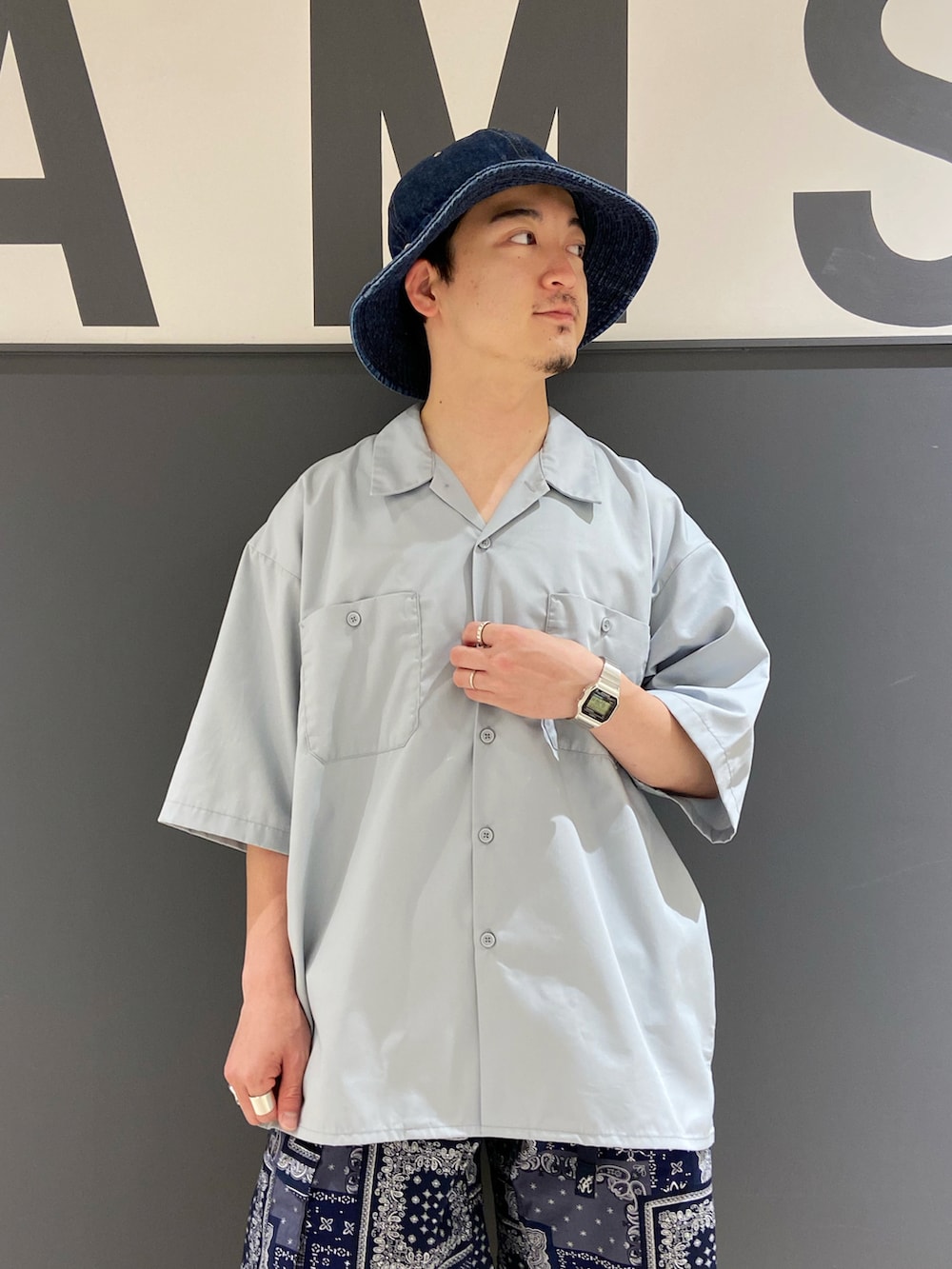 グレー系のシャツ/ブラウス、ブルー系のバッグ、ブラウン系のローファーを着用したメンズの夏コーディネートの3枚目の写真