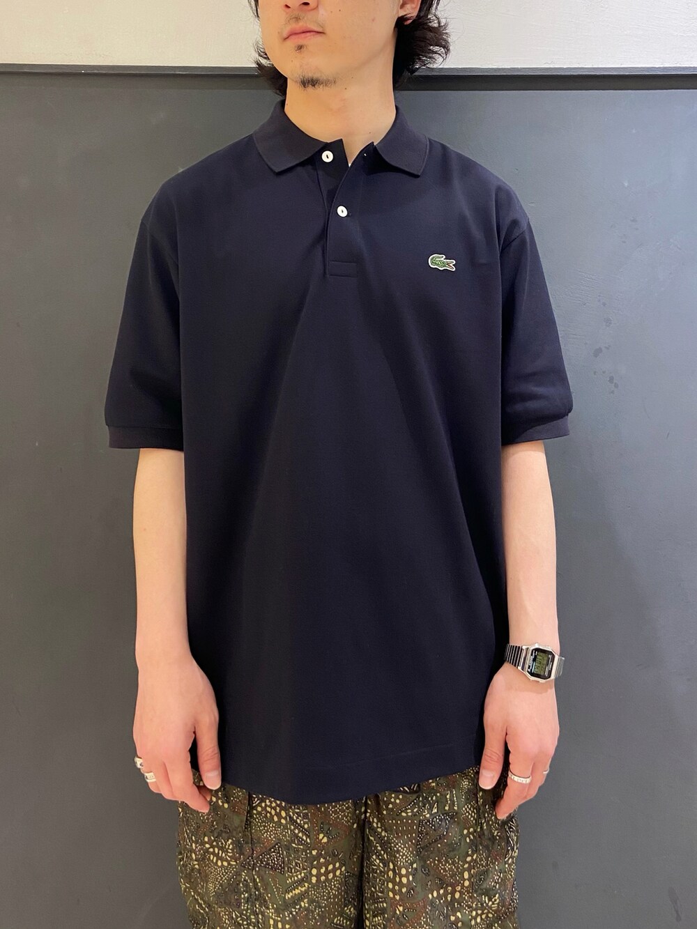 ブルー系のポロシャツ、グリーン系のカーゴパンツ、ブラック系のローファーを着用したメンズの夏コーディネートの3枚目の写真