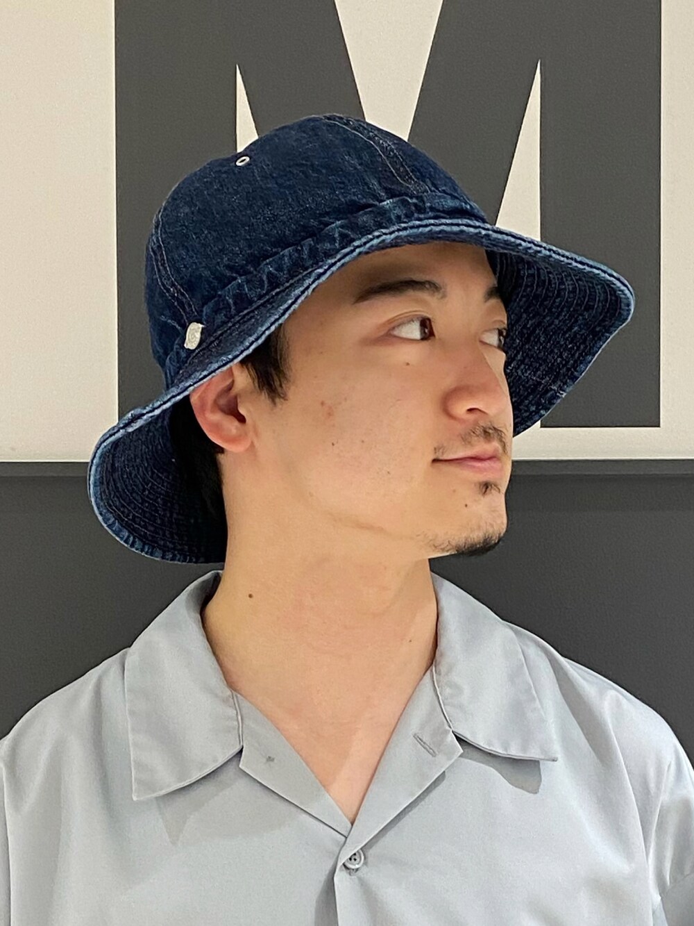 グレー系のシャツ/ブラウス、ブルー系のバッグ、ブラウン系のローファーを着用したメンズの夏コーディネートの2枚目の写真