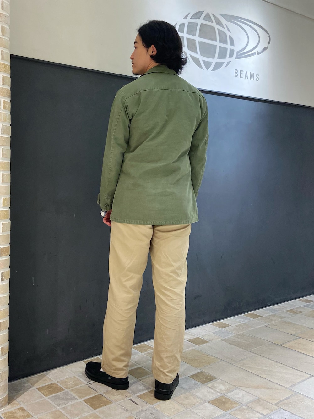 ブルー系のシャツ/ブラウス、ベージュ系のチノパンツ、ブラック系のローファーを着用したメンズの夏コーディネートの2枚目の写真