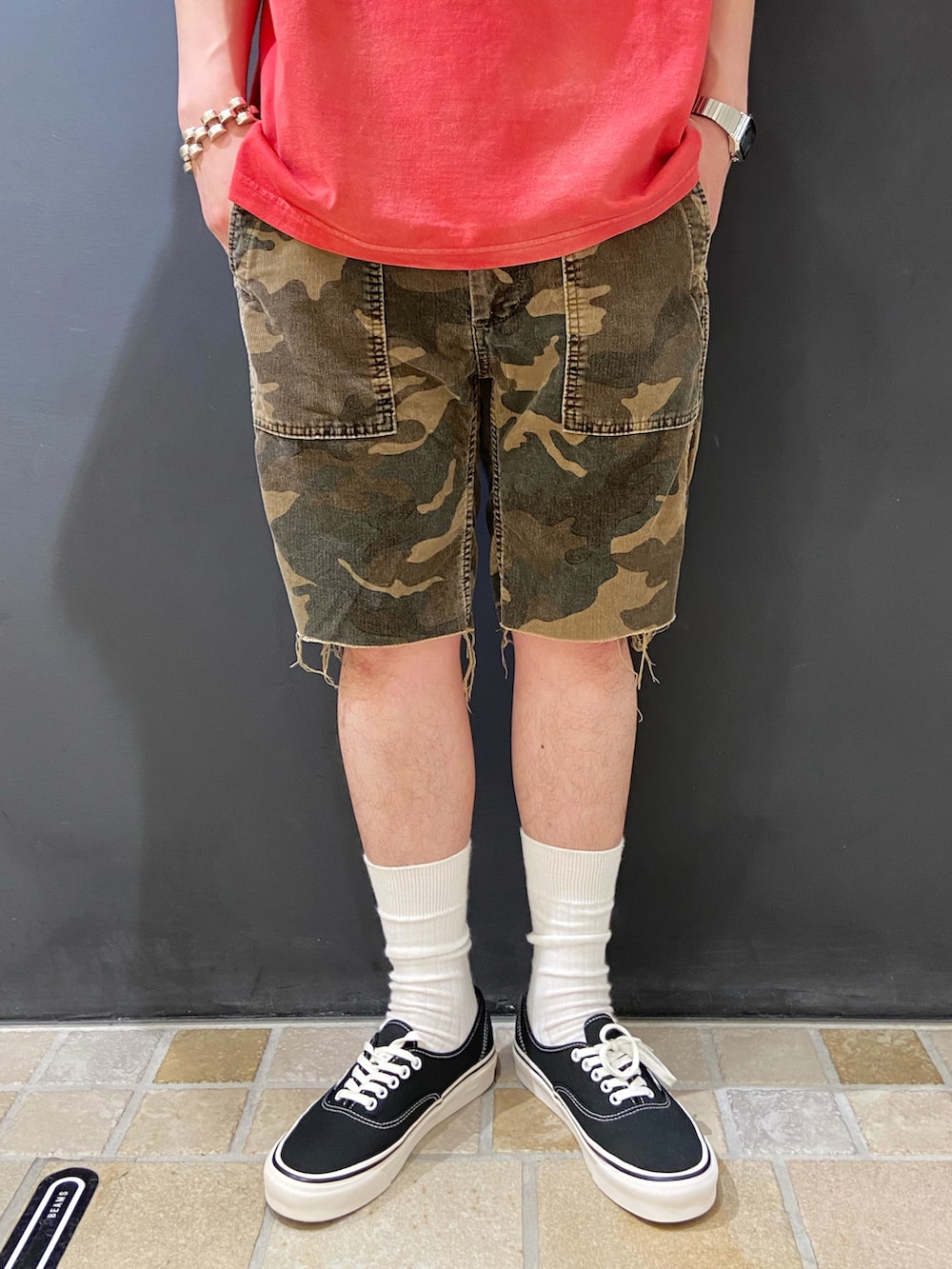 レッド系のTシャツ/カットソー、グリーン系のパンツ、ブラック系のスニーカーを着用したメンズの夏コーディネートの5枚目の写真