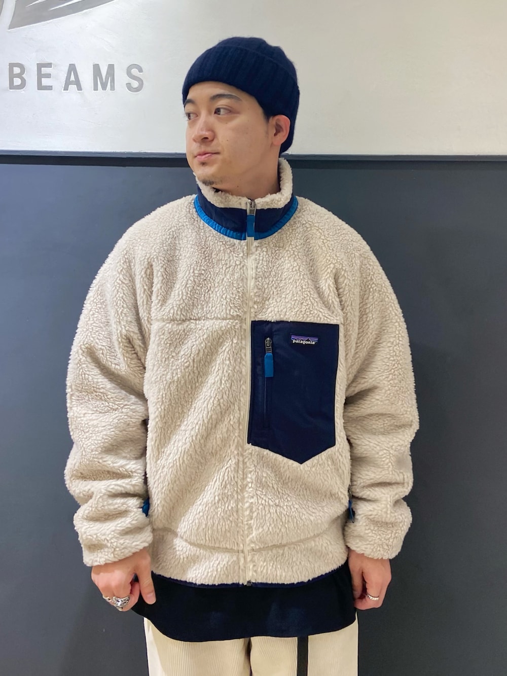 ホワイト系のブルゾン、ブルー系のモカシン/デッキシューズ、ホワイト系のパンツを着用したメンズの秋コーディネートの3枚目の写真