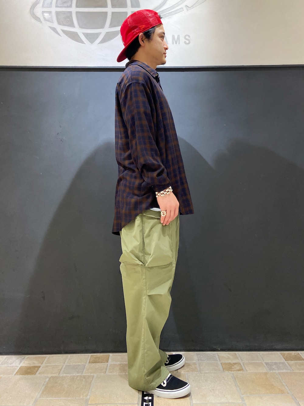 ブルー系のシャツ/ブラウス、グリーン系のその他パンツ、ブラック系のスニーカーを着用したメンズの夏コーディネートの2枚目の写真