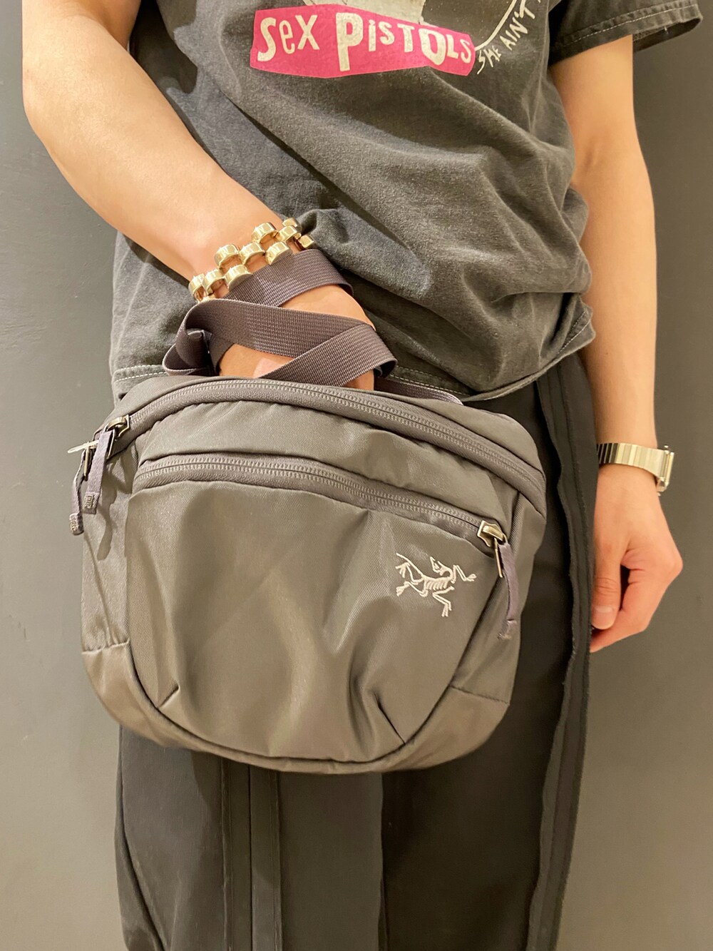 ブラック系のパンツ、ブラック系のサンダル、グレー系のボディバッグ/ウエストポーチを着用したメンズの夏コーディネートの4枚目の写真