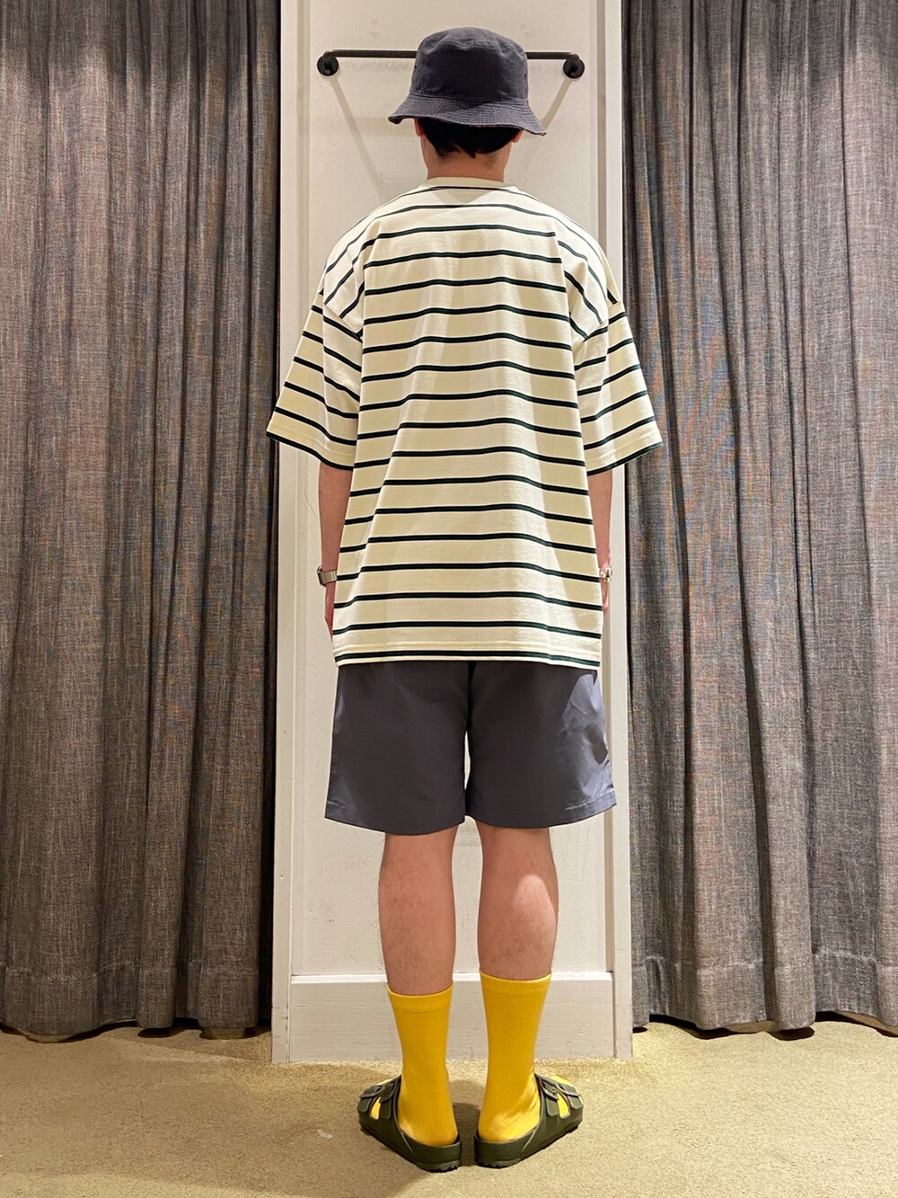 ホワイト系のTシャツ/カットソー、グレー系のパンツ、グリーン系のサンダルを着用したメンズの夏コーディネートの3枚目の写真