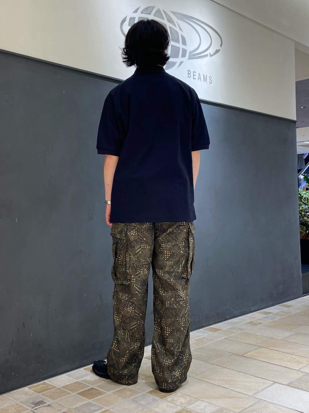 ブルー系のポロシャツ、グリーン系のカーゴパンツ、ブラック系のローファーを着用したメンズの夏コーディネートの2枚目の写真