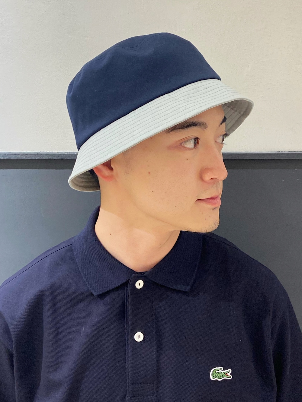 ブルー系のポロシャツ、ブルー系のチノパンツ、ブラック系のサンダルを着用したメンズの夏コーディネートの4枚目の写真