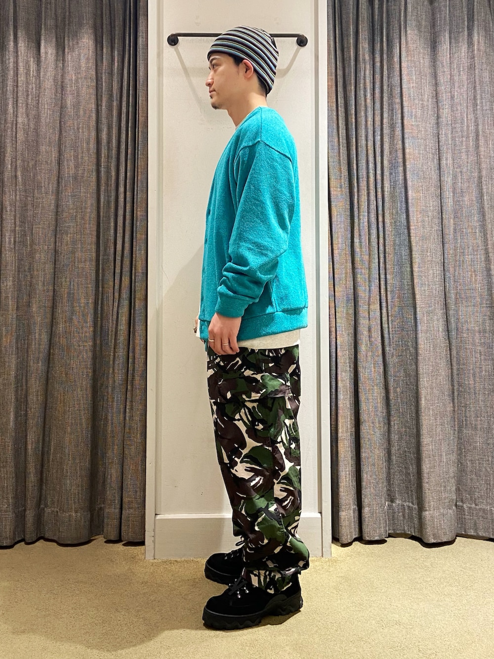ブルー系のカーディガン/ボレロ、グリーン系のカーゴパンツ、ブラック系のスニーカーを着用したメンズの秋コーディネートの2枚目の写真