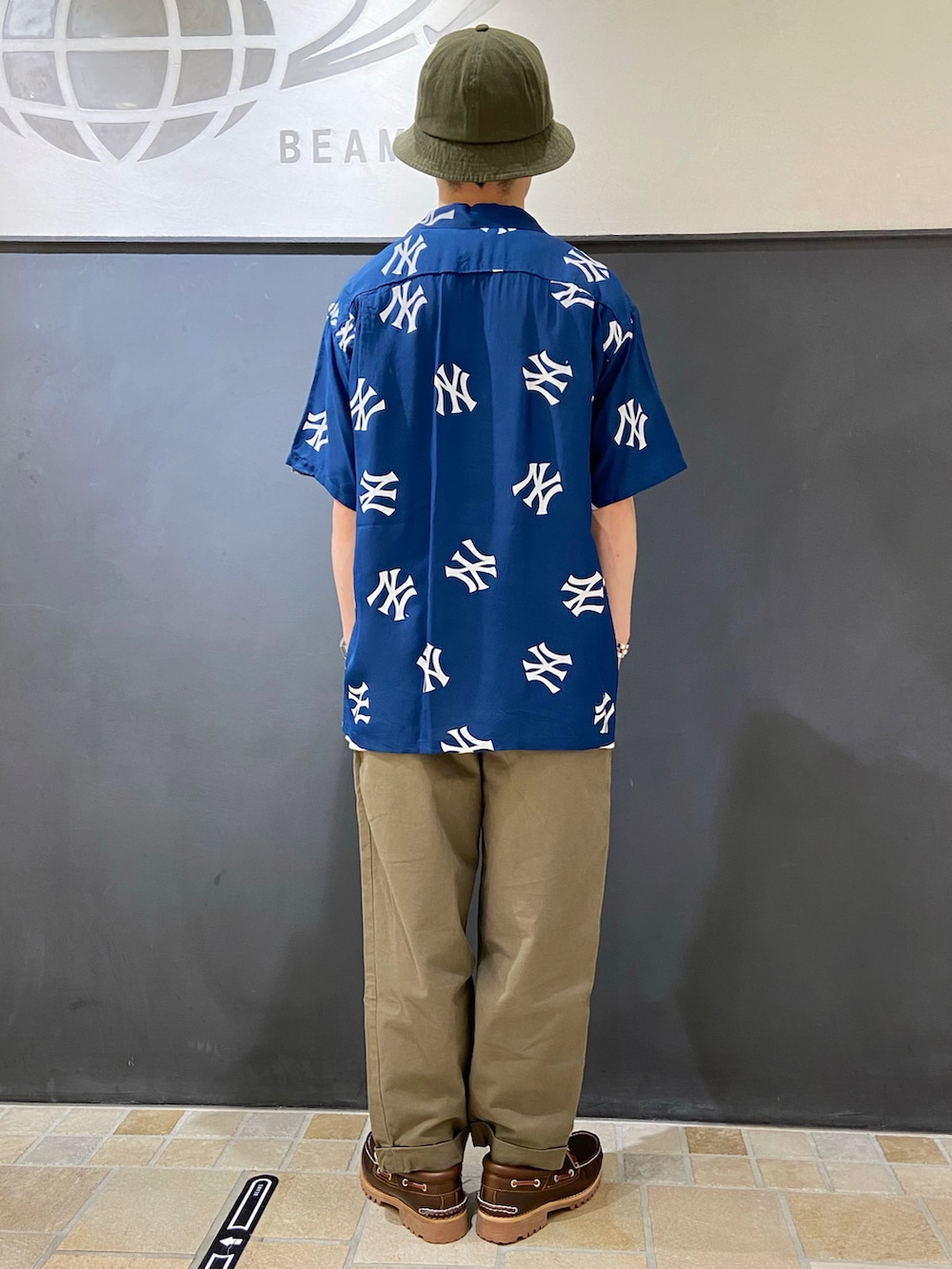 ブルー系のシャツ/ブラウス、ホワイト系のTシャツ/カットソー、ブラウン系のモカシン/デッキシューズを着用したメンズの夏コーディネートの2枚目の写真