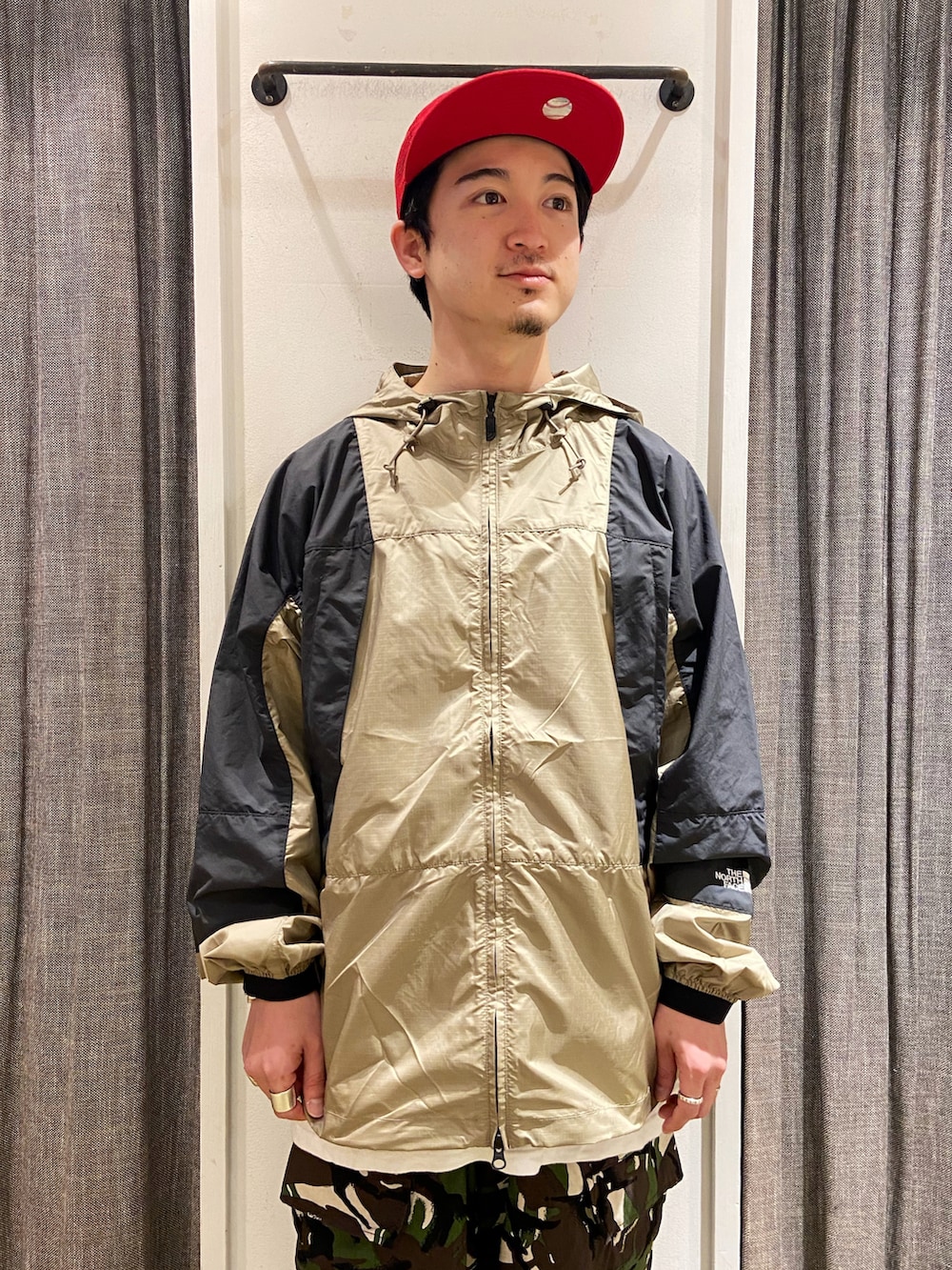 ベージュ系のマウンテンパーカー、グリーン系のカーゴパンツ、ベージュ系のシューズを着用したメンズの夏コーディネートの4枚目の写真