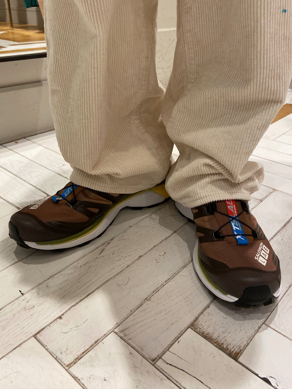 ブラウン系のテーラードジャケット、ホワイト系のパンツ、ブラウン系のスニーカーを着用したメンズの秋コーディネートの5枚目の写真