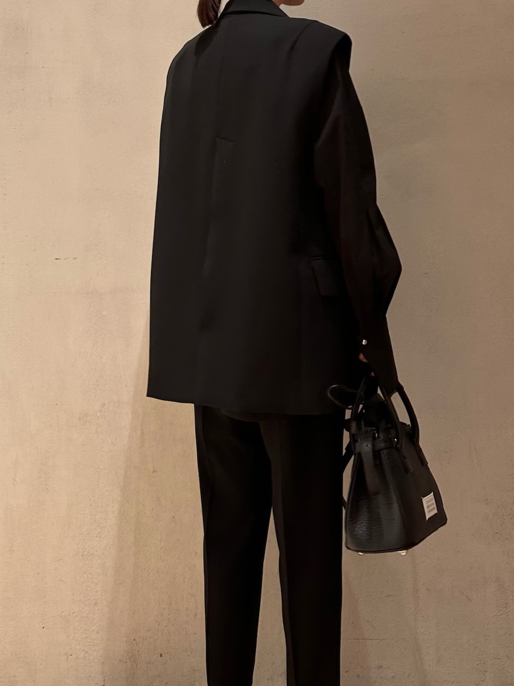 ブラック系のショルダーバッグ、ブラック系のテーラードジャケット、ブラック系のその他パンツを着用したレディースの春コーディネートの4枚目の写真