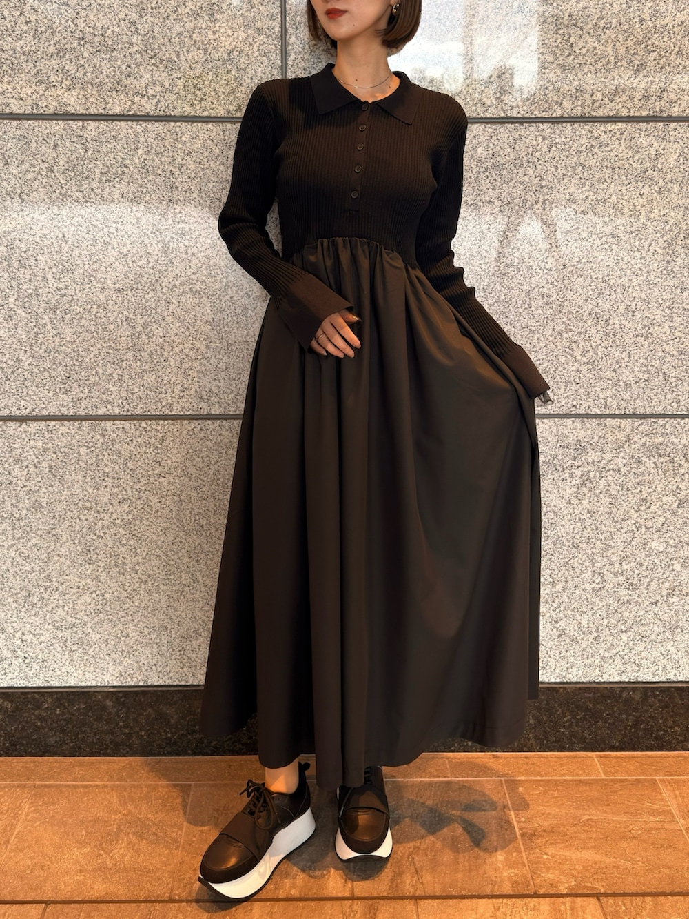 ブラック系のワンピース、ブラック系のスニーカーを着用したレディースの春コーディネートの2枚目の写真