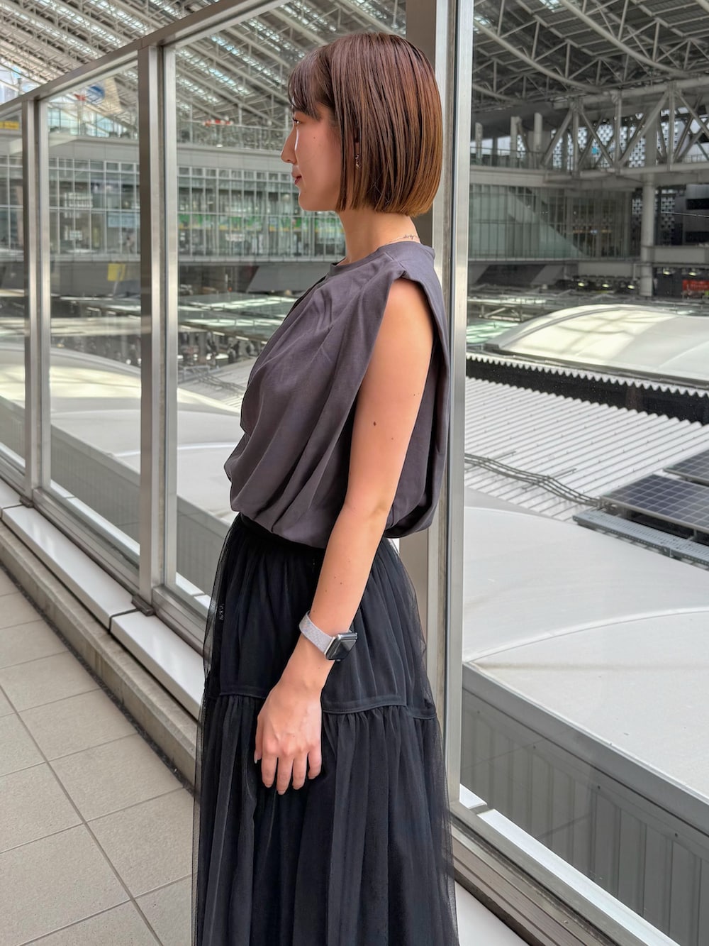 グレー系のTシャツ/カットソー、ブラック系のスカート、レッド系のショルダーバッグを着用したレディースの夏コーディネートの4枚目の写真