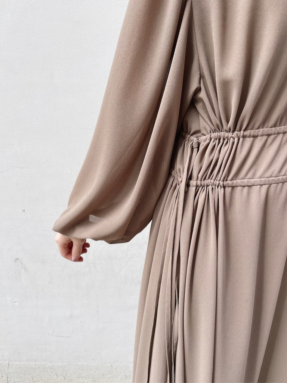 グリーン系のパンプス、ベージュ系のワンピースを着用したレディースの冬コーディネートの5枚目の写真